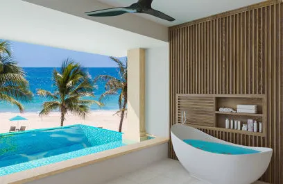 A tropical all-inclusive hotel room looking out at the beach and ocean