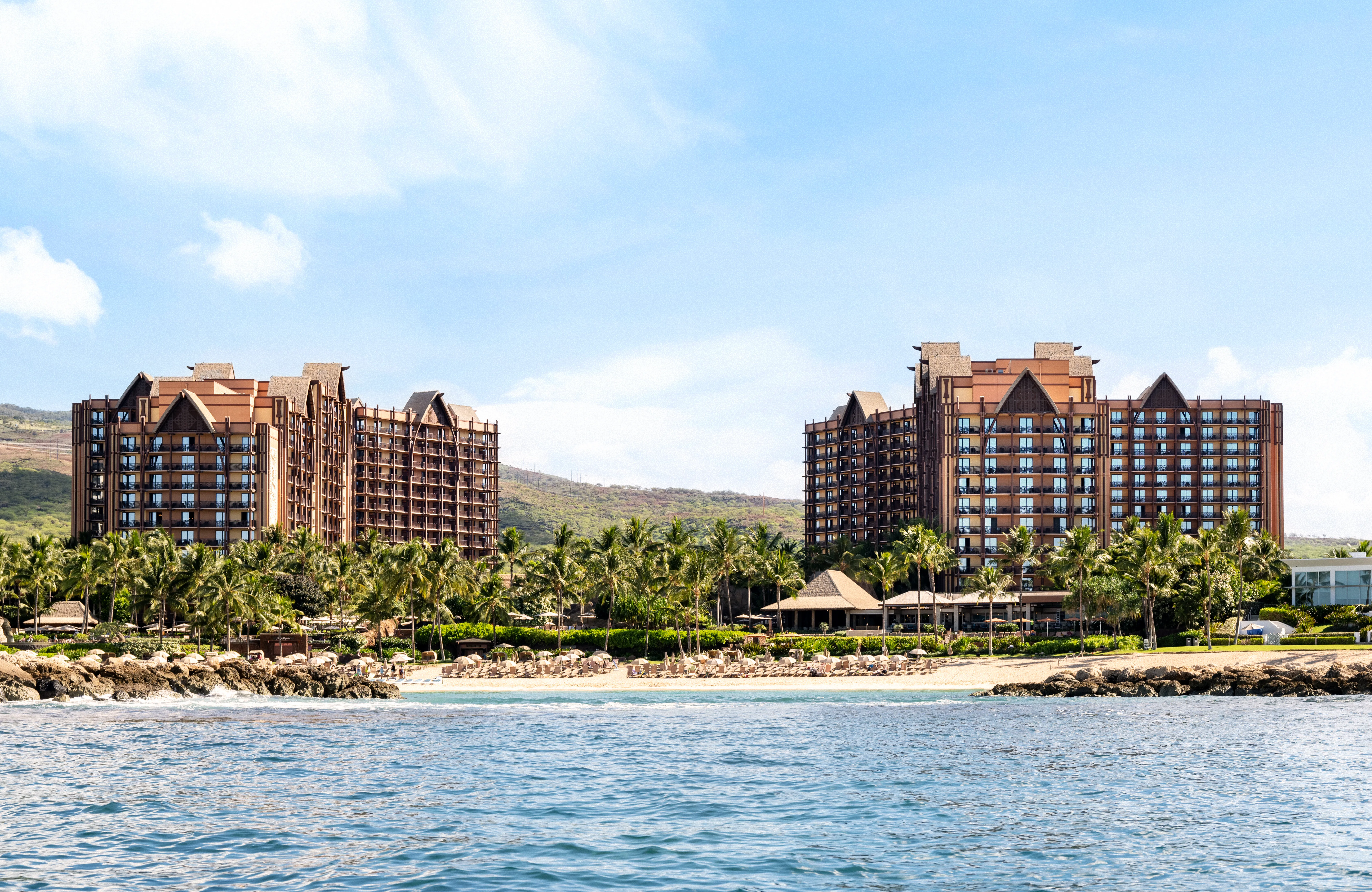 Off-shore photo of the tropical Disney's Aulani resort, there are two large hotel buildings
