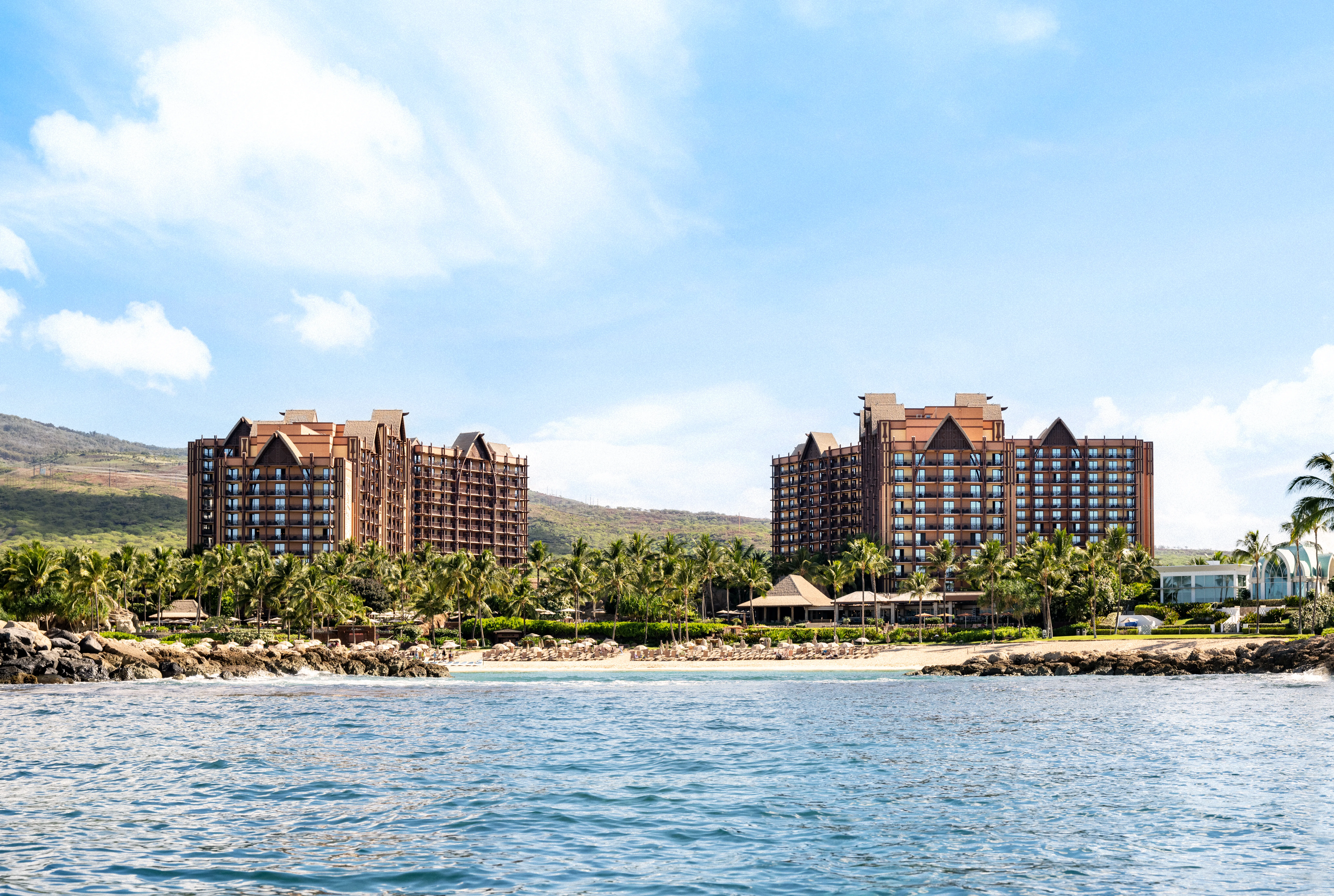 Off-shore photo of the tropical Disney's Aulani resort, there are two large hotel buildings
