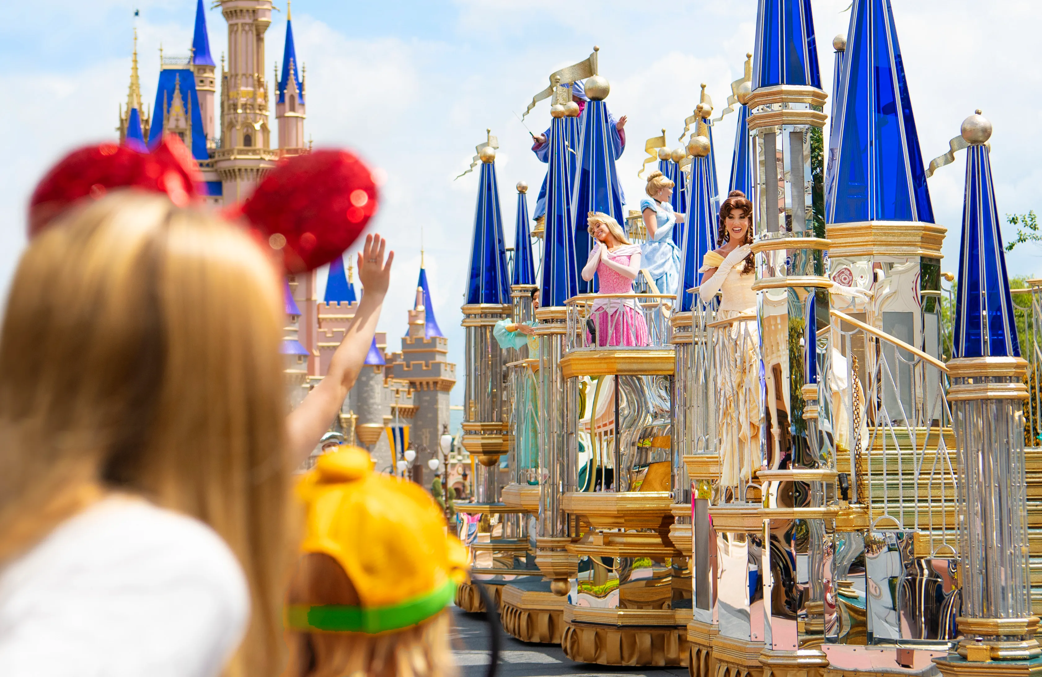 A child looking at a Disney float with Disney princesses on it
